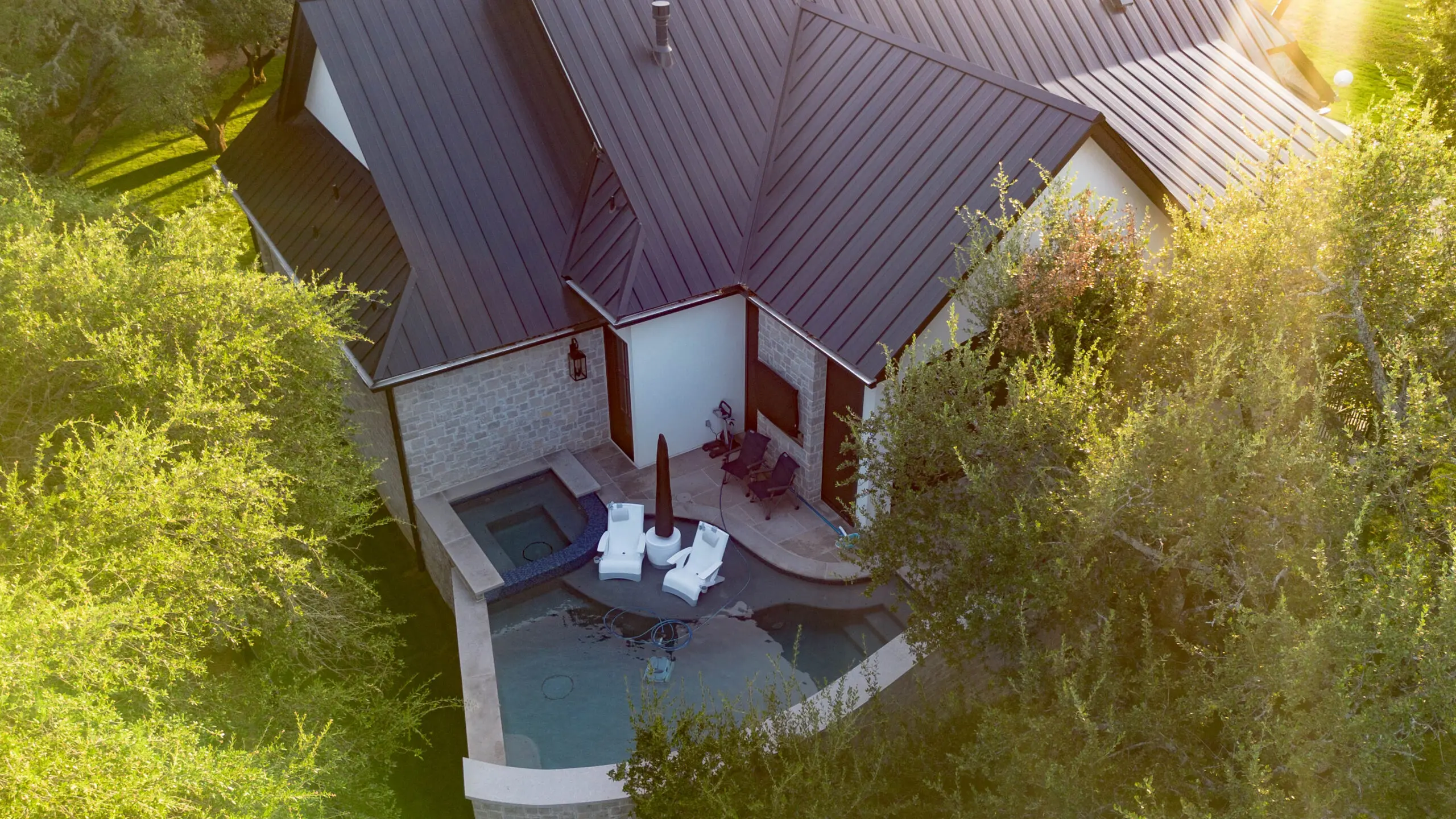 Aerial view of a modern house with a cozy outdoor patio and hot tub.