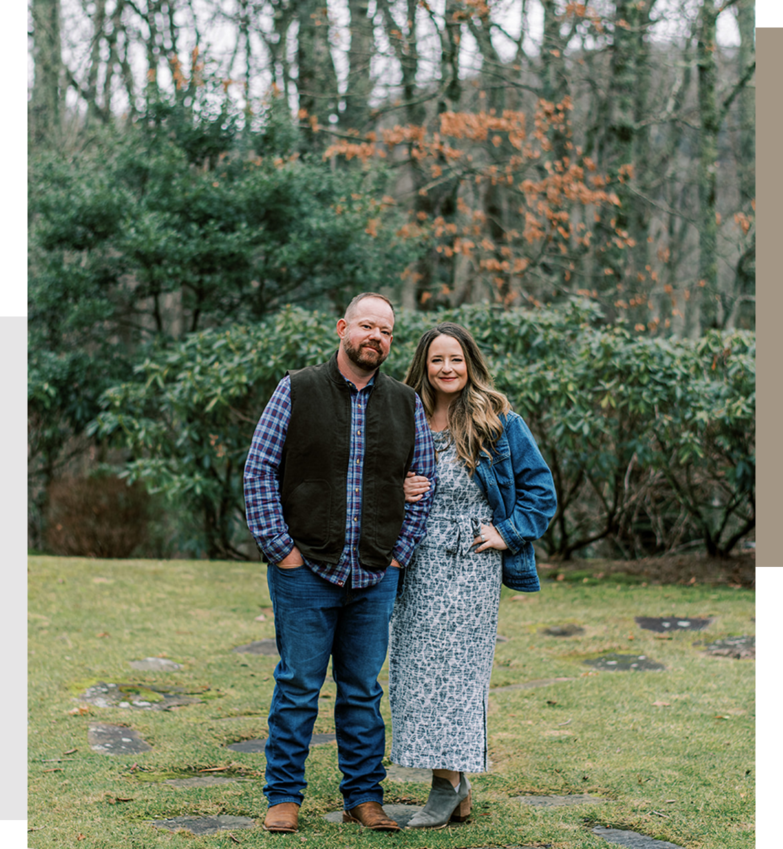 A smiling couple stands outdoors in casual autumn attire.