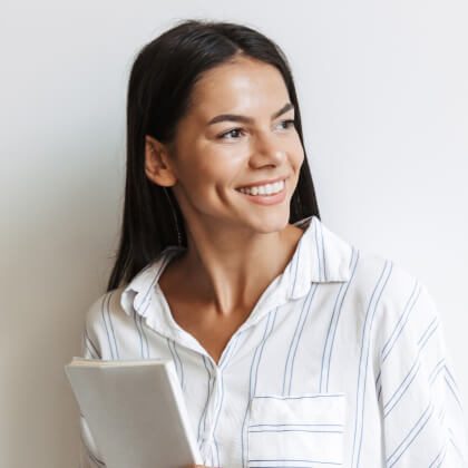 A smiling woman holding a tablet, looking away.