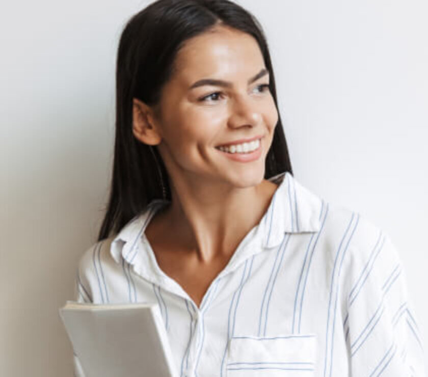 A smiling woman holding a tablet, looking away.