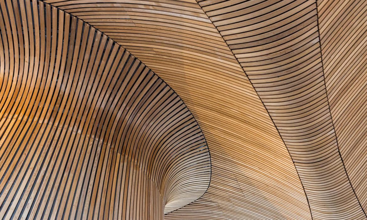 Curved wooden ceiling with parallel slats.