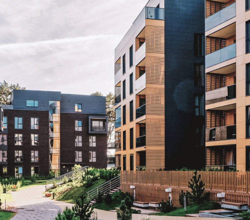 Modern apartment buildings with landscaped courtyard and greenery.