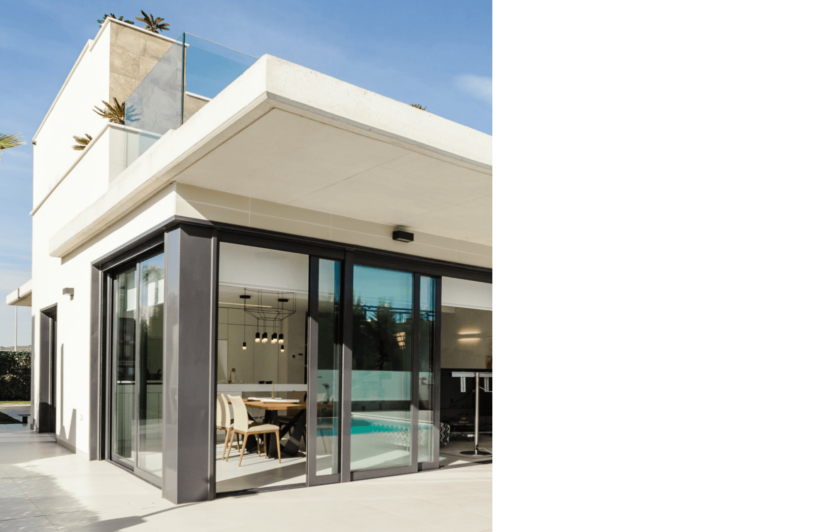 Modern building entrance with glass doors and outdoor seating.