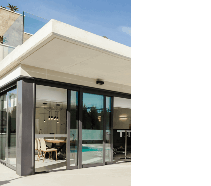 Modern building entrance with glass doors and outdoor seating.
