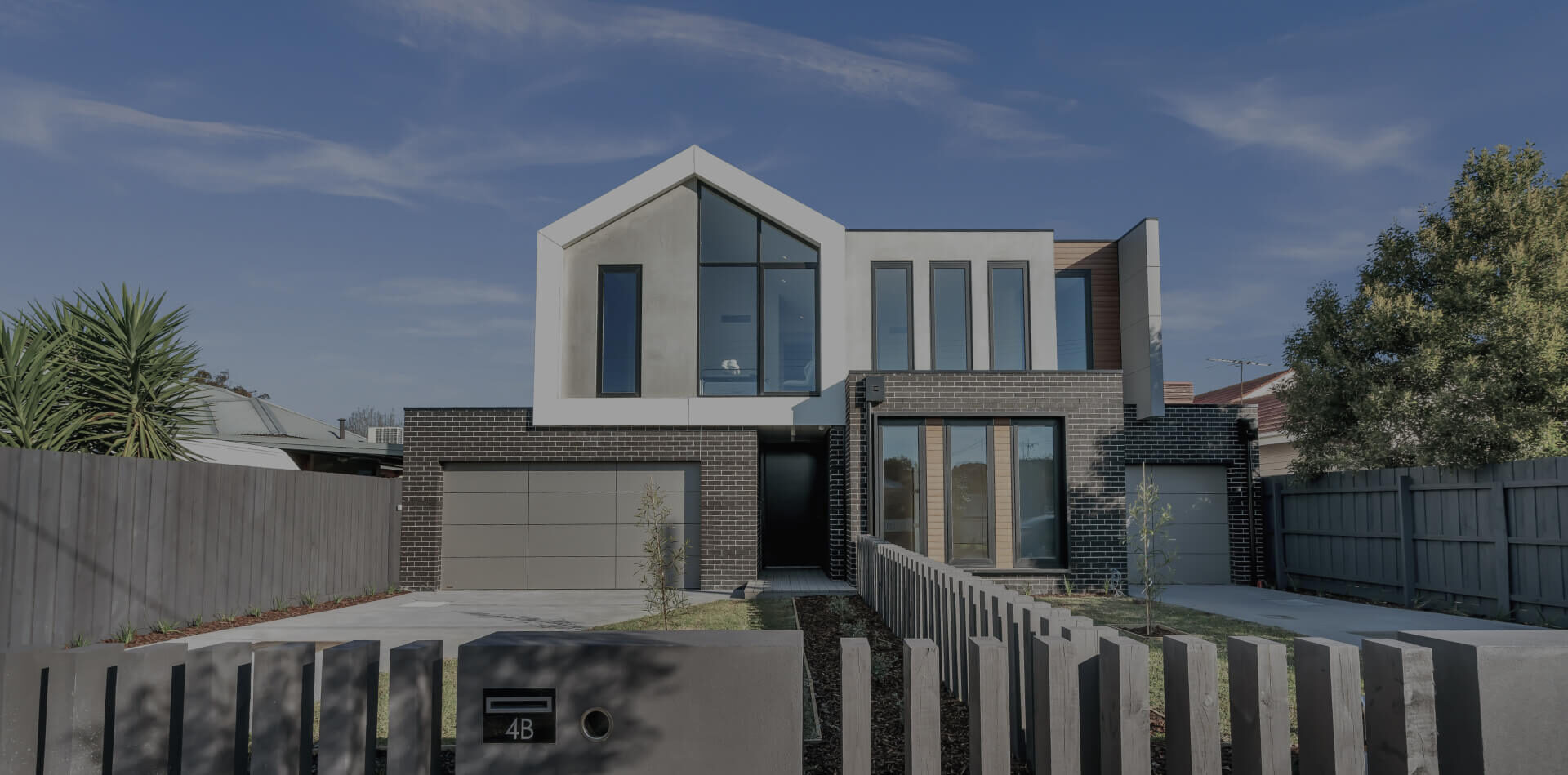 Modern two-story house with large windows and garage.