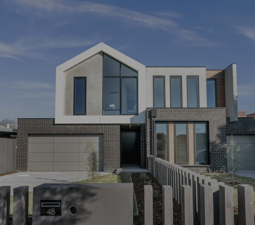 Modern two-story house with large windows and garage.