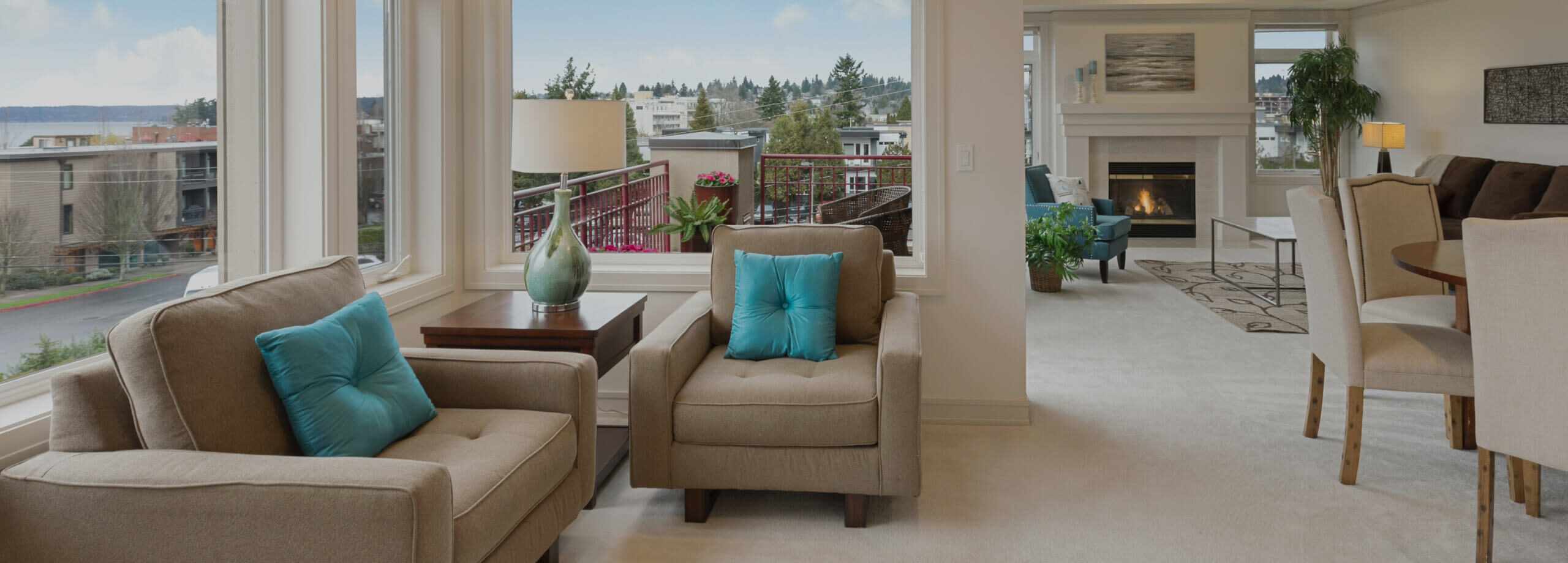A cozy beige armchair with a teal pillow on a patio.