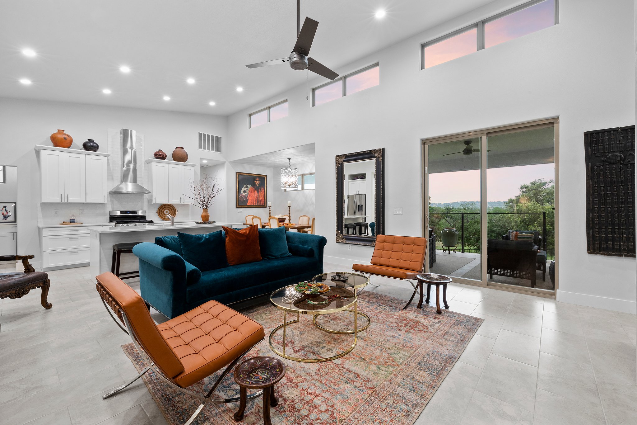 Modern living room with teal sofa and brown leather chairs.