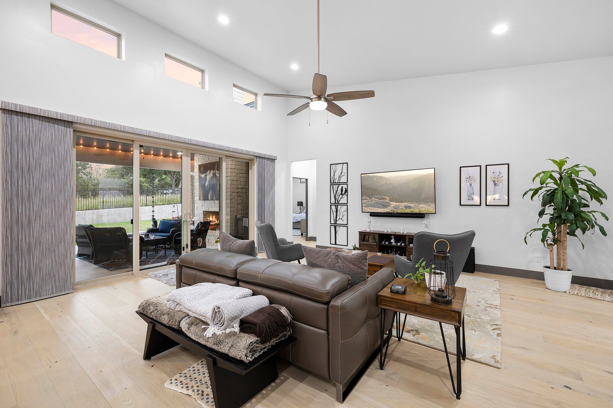 Modern living room with leather sofa and ceiling fan.