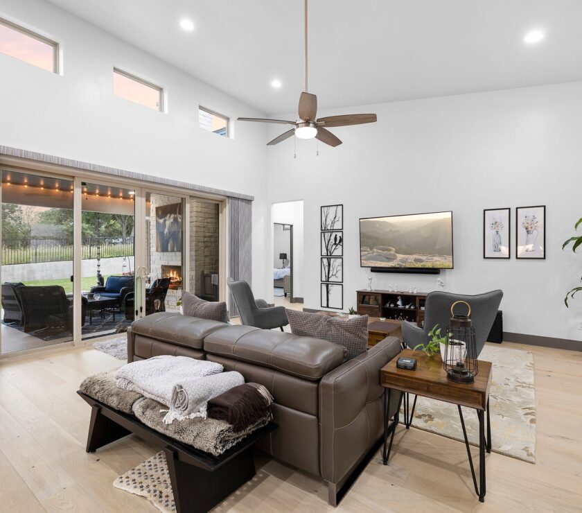Modern living room with leather sofa and ceiling fan.