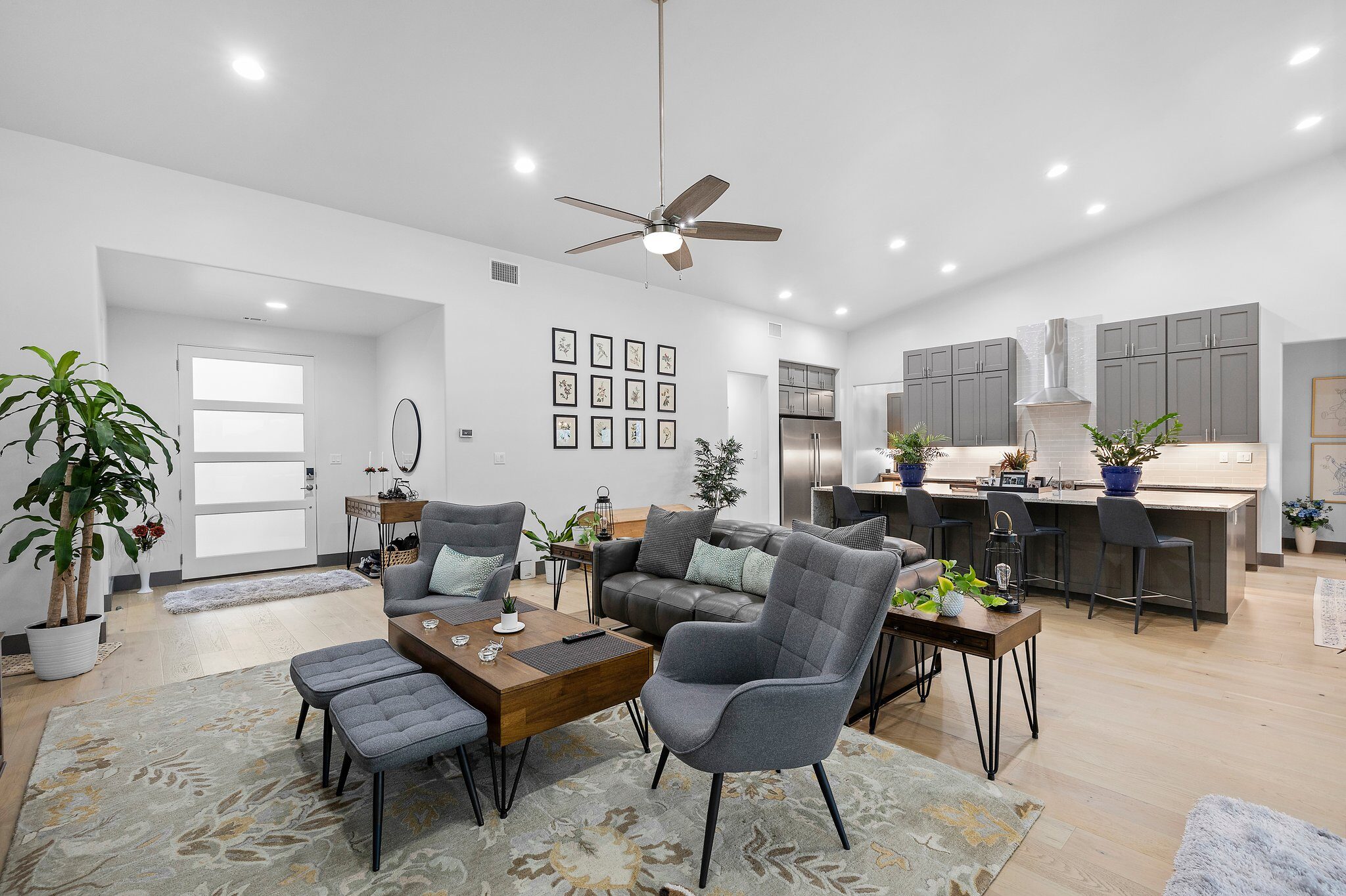 Modern living room with gray chairs and wooden coffee tables.