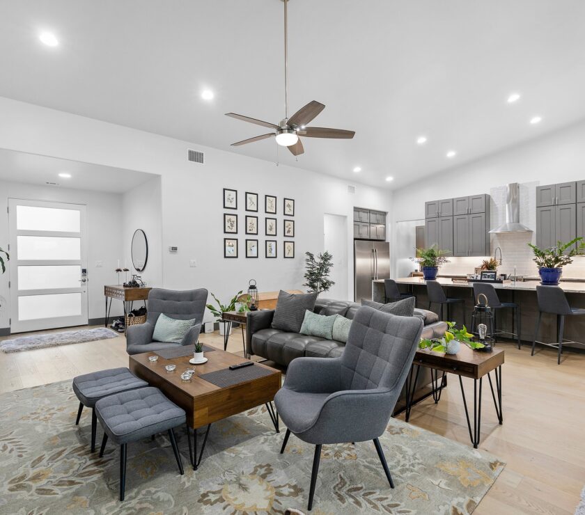 Modern living room with gray chairs and wooden coffee tables.
