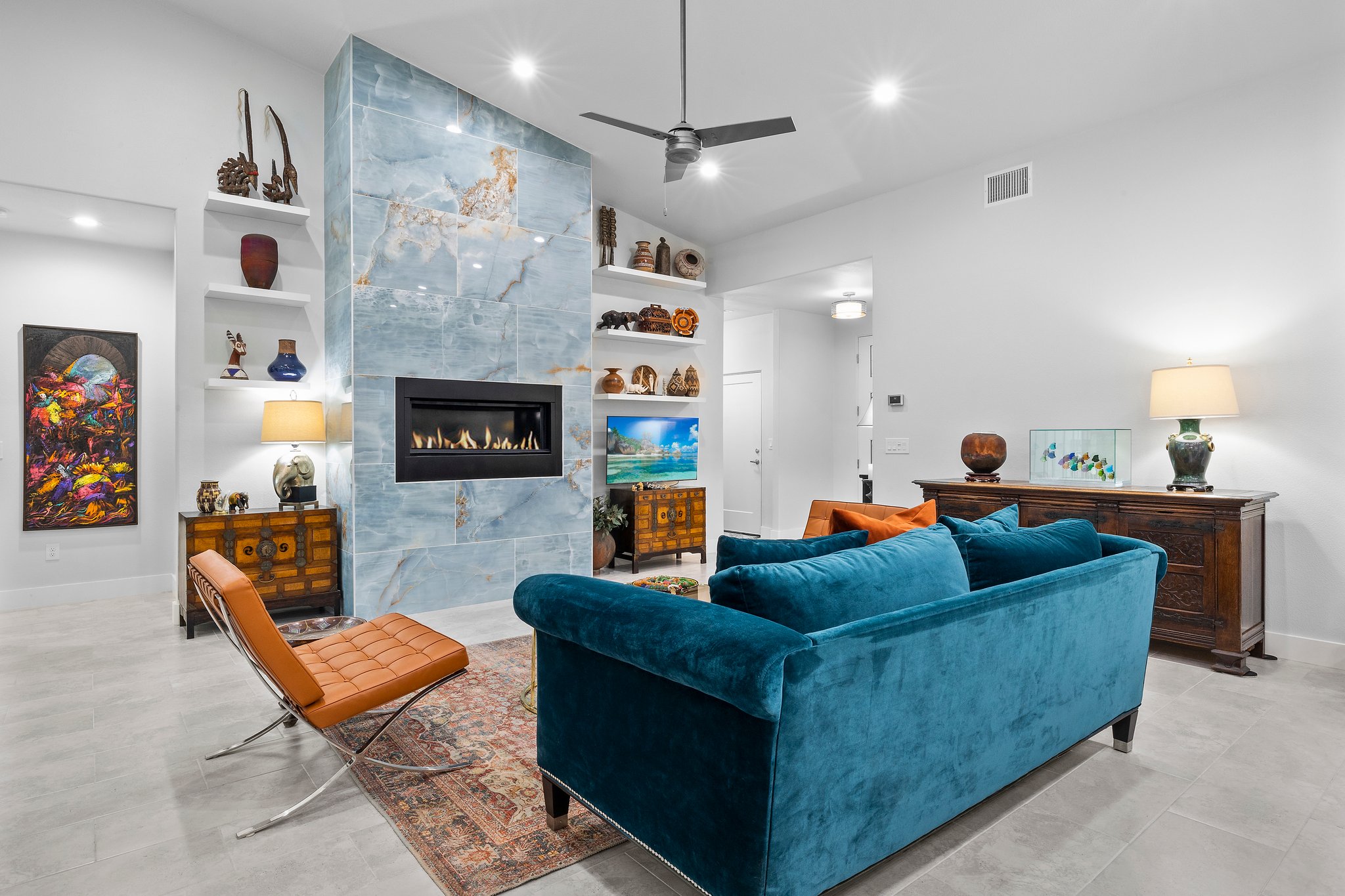 Modern living room with teal sofa and stone fireplace.