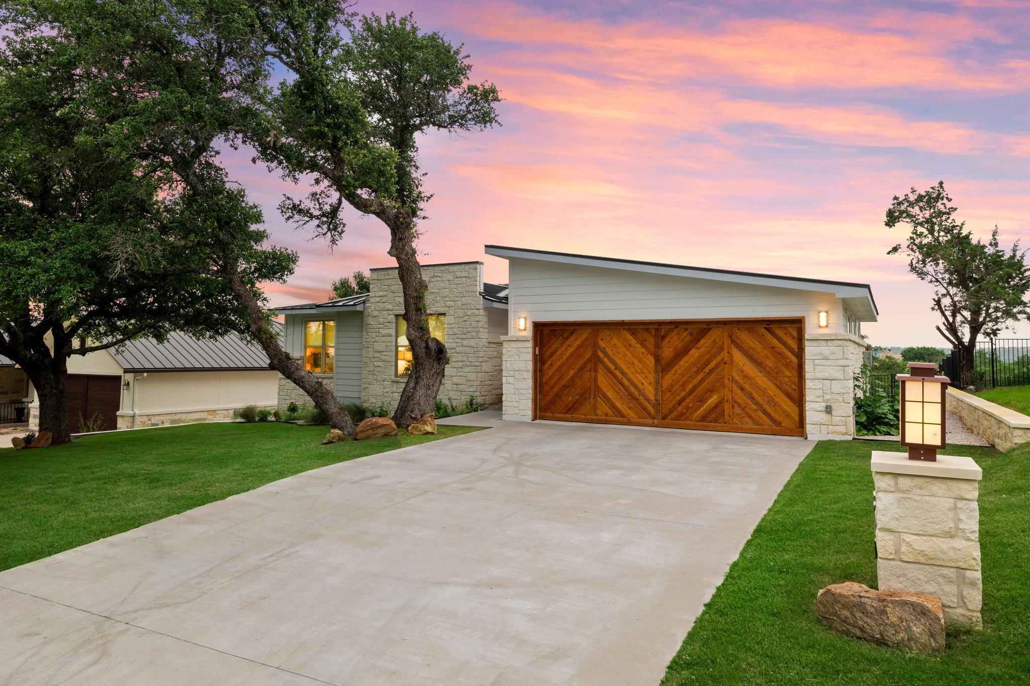 Modern house with wooden garage door at sunset.
