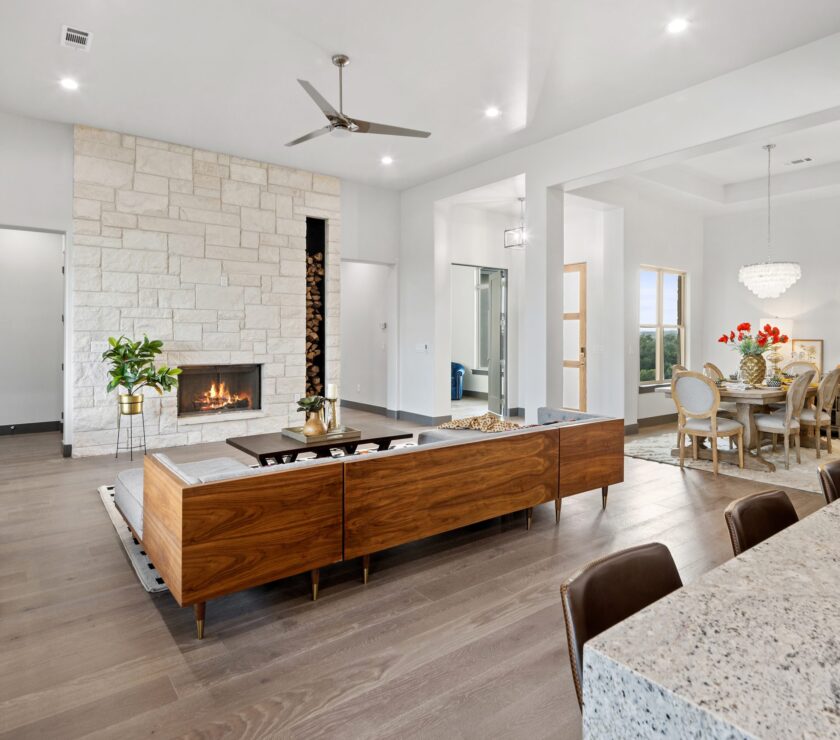 Modern living room with a stone fireplace and wooden furniture.