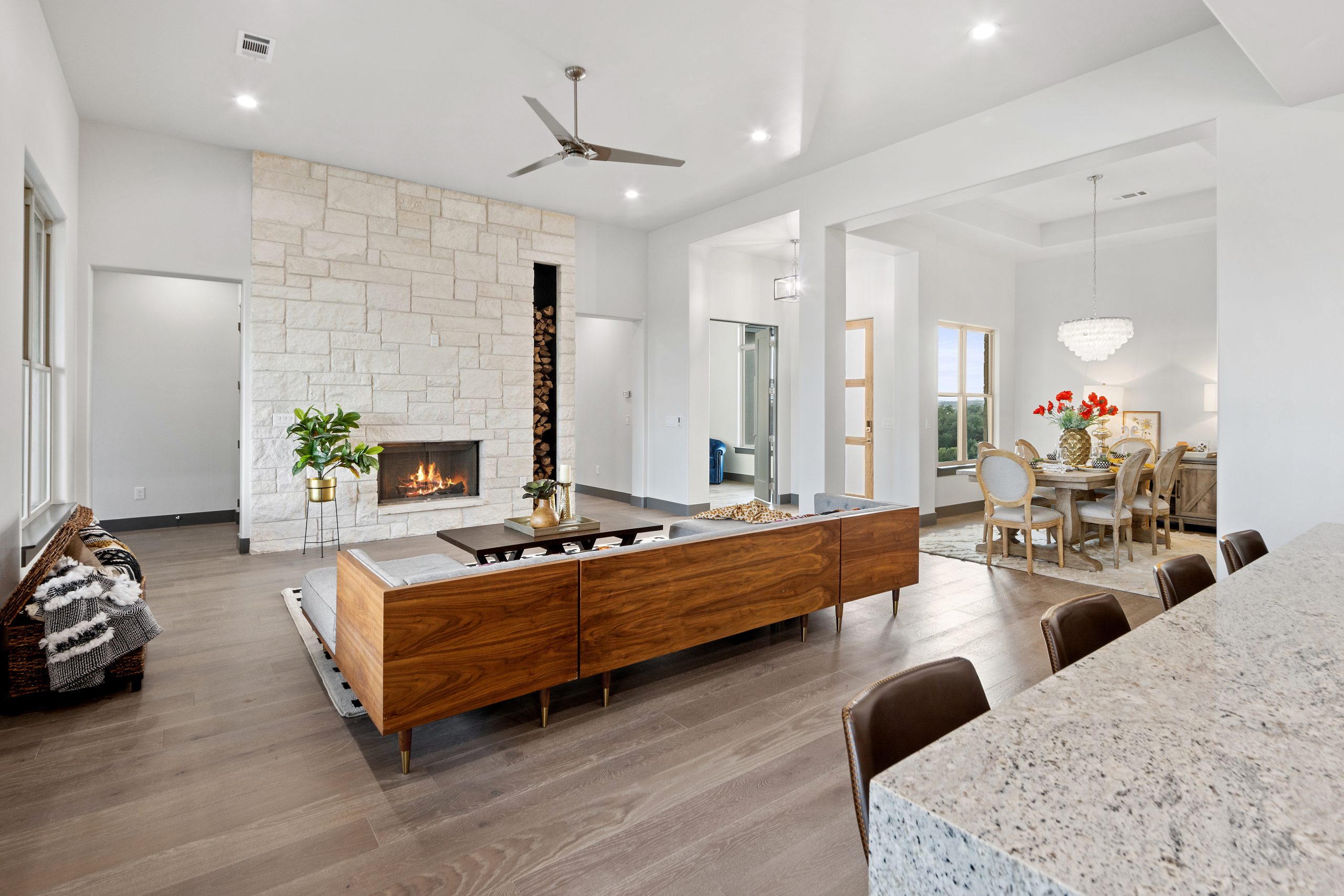 Modern living room with a stone fireplace and wooden furniture.