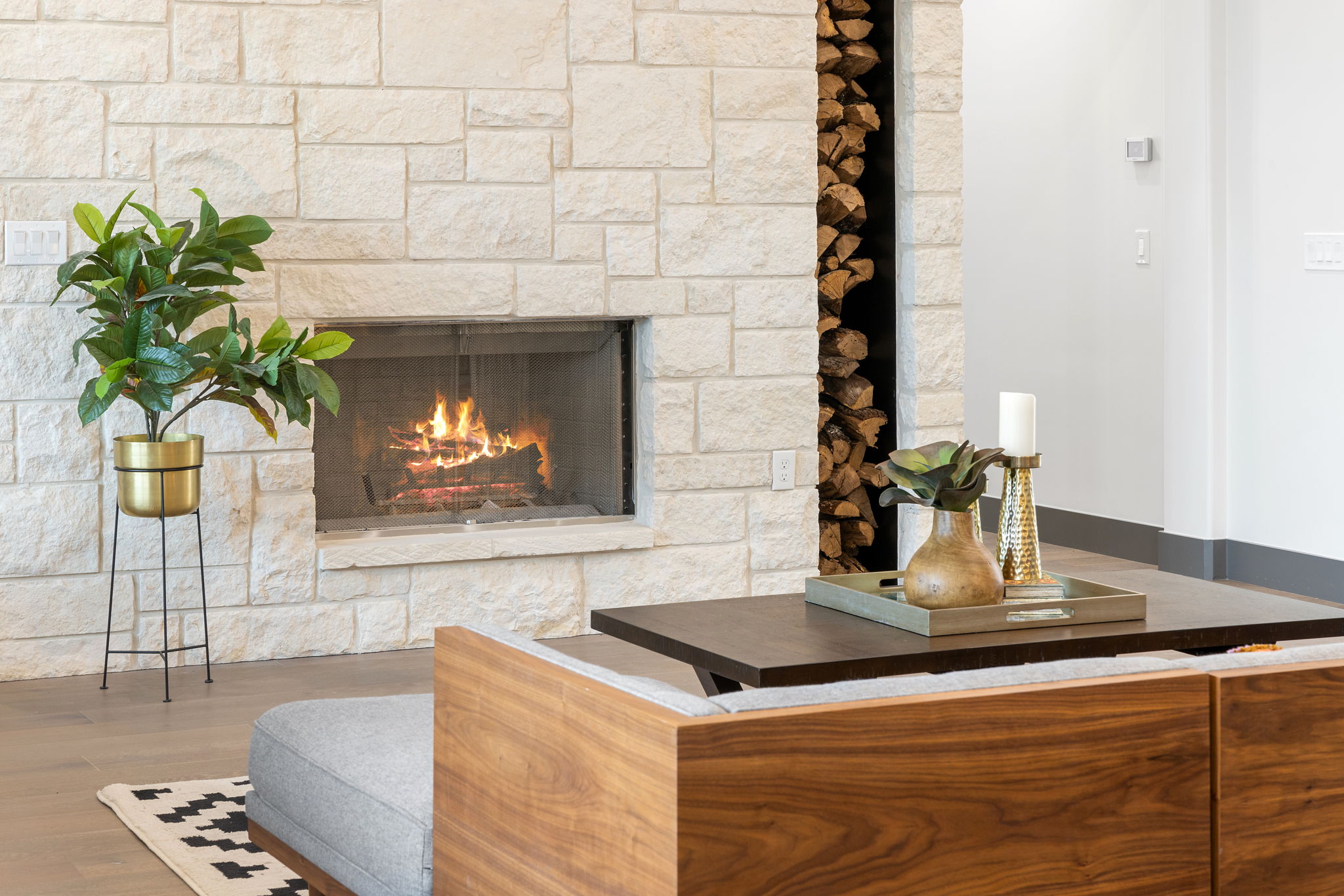 Cozy modern living room with a lit fireplace and wooden accents.